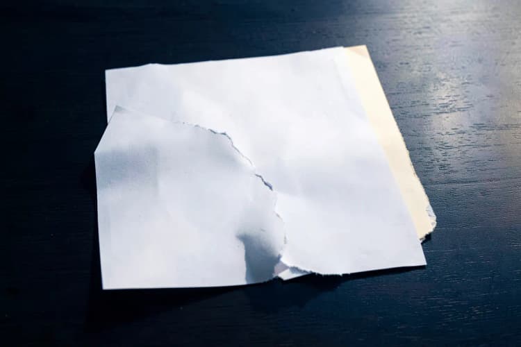 Um documento legal sendo rasgado ao meio, representando a dissolução de uma sociedade.