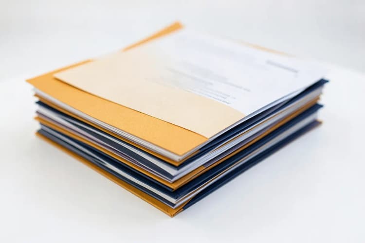Uma pilha de documentos organizados em pastas, simbolizando a documentação necessária para a apuração de haveres.