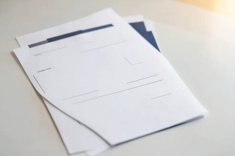Um modelo de documento com espaços em branco para preenchimento, em plano médio, com luz de escritório vinda da direita.